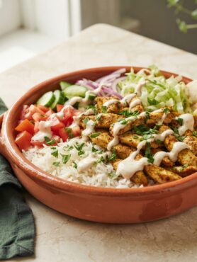 Chicken Shawarma Bowls with Garlic Sauce - golden spiced chicken over rice with fresh vegetables and creamy sauce